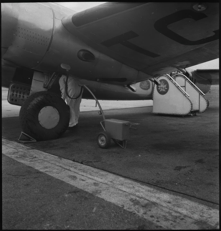 Mechanic servicing Lockheed 14 H2 aircraft of trans Canada Air Lines en route to Moncton 16 October 1939.